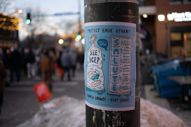 A poster in blue that says "Protect Each Other! See ICE? SALUTE!"